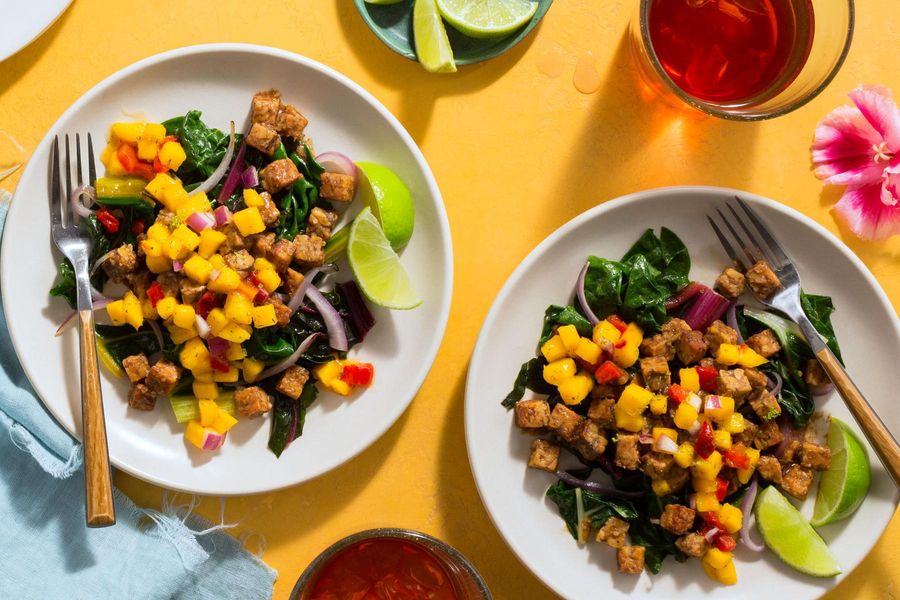 Spicy Jamaican jerk tempeh with sautéed greens and mango salsa