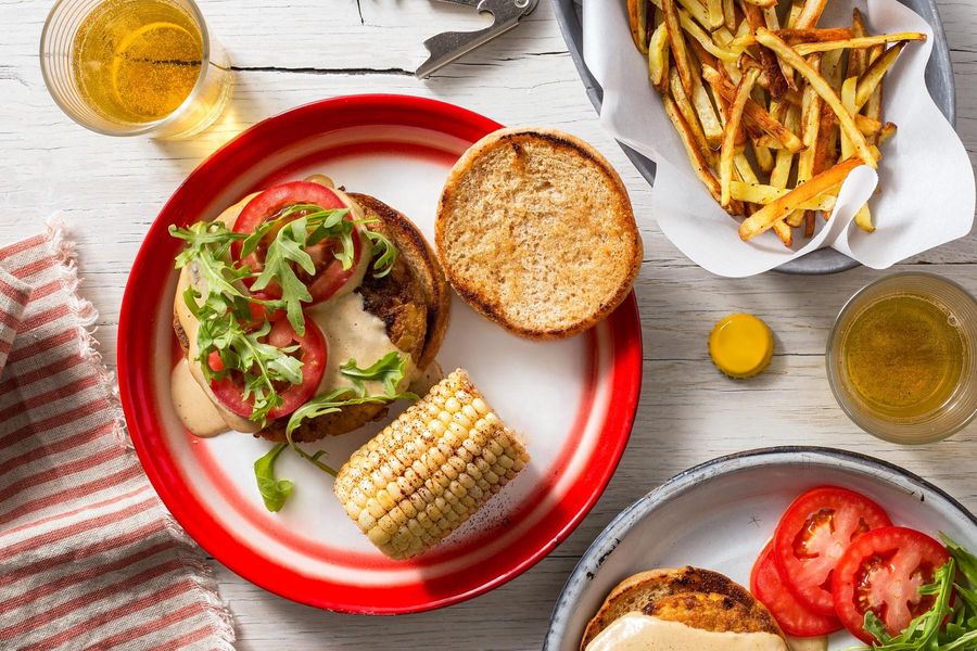 “Cheesy” tofu burgers with corn on the cob and roasted matchstick fries