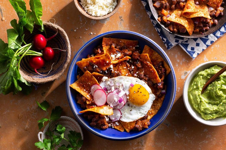 Chipotle chilaquiles with black beans, fried eggs, and guacamole