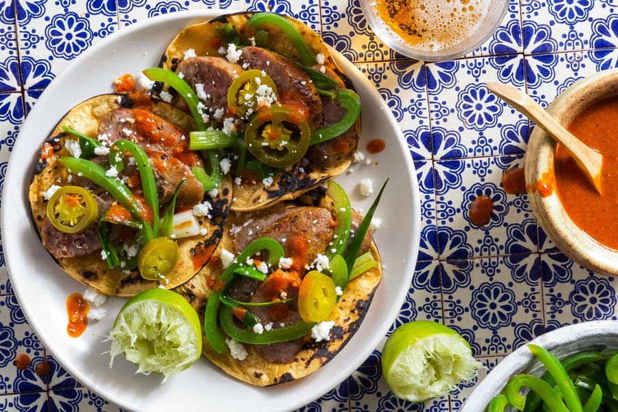 Sausage tacos with bell pepper, chile salsa, and queso fresco